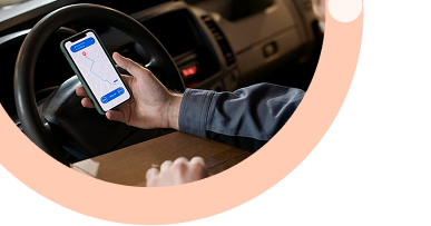 Stay Ahead with Real-Time Visibility: Delivery driver in vehicle using mobile device for real-time fleet visibility and route optimization to maintain competitive advantage